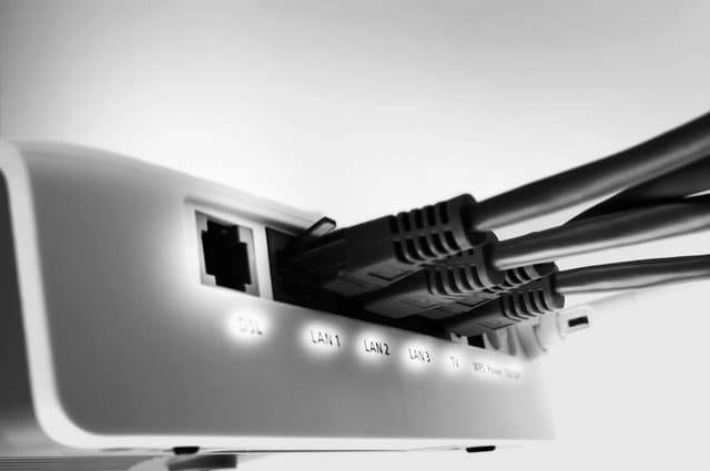 Close‑up of multiple ethernet cables plugged into the ports of a network router.