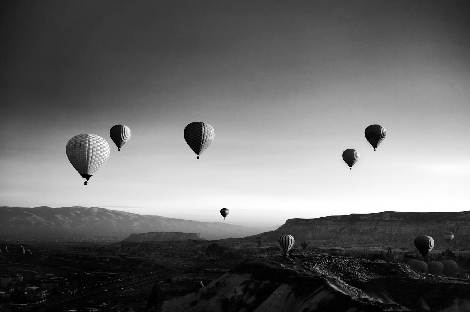 Beautiful sunrise over geology landscape of Cappadocia with hot air balloons and the take off site, a view from sunrise view point, Goreme ancient town.