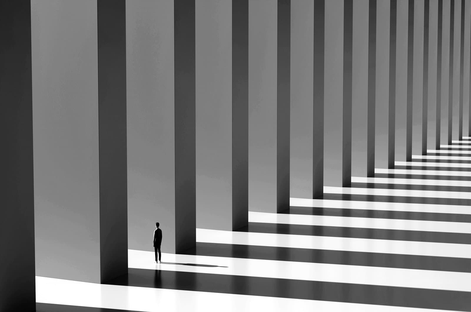 Man standing between two columns in a vast row contemplating business direction and future opportunities