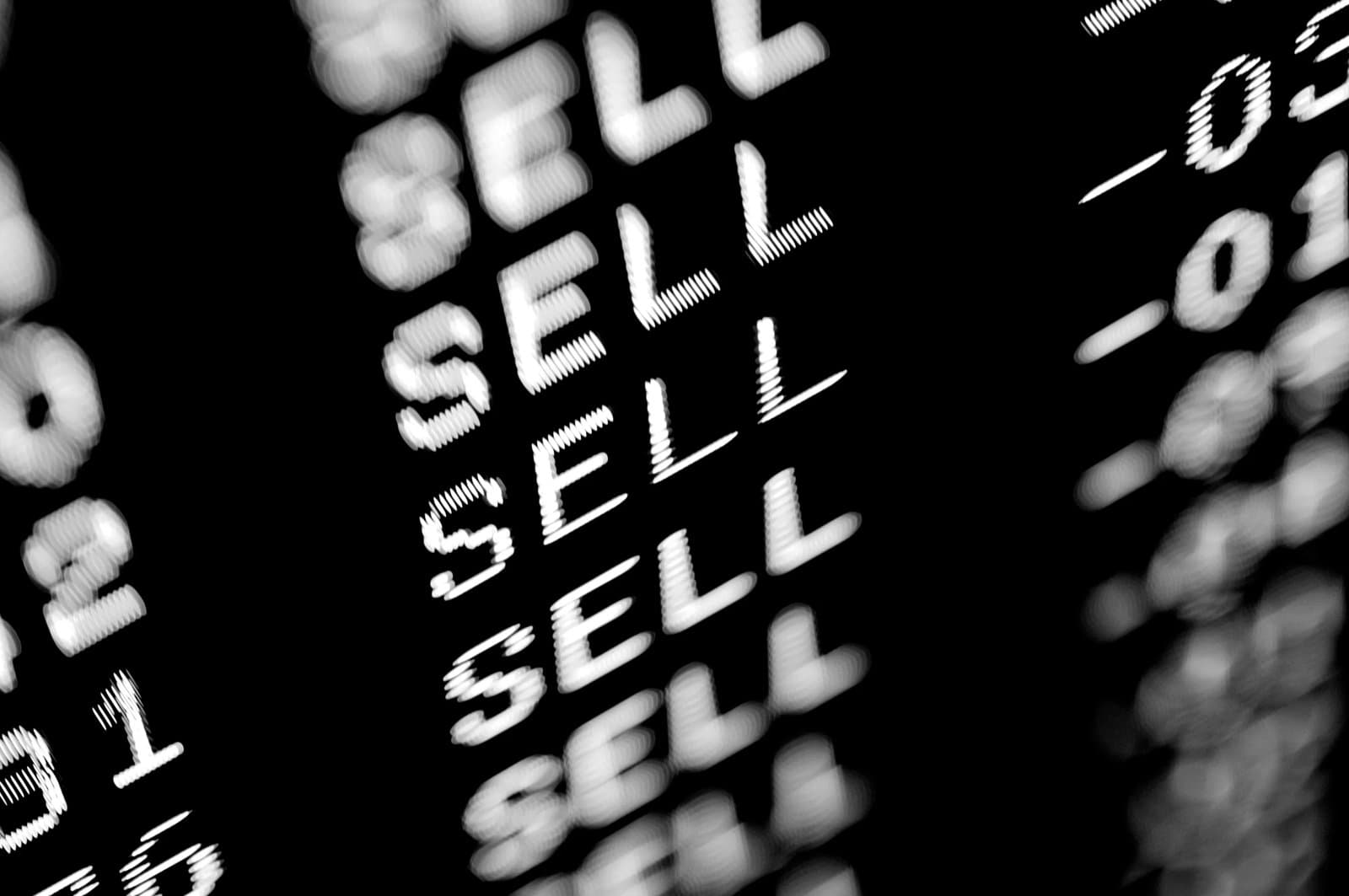 Close-up of a digital stock market display showing the word "sell"