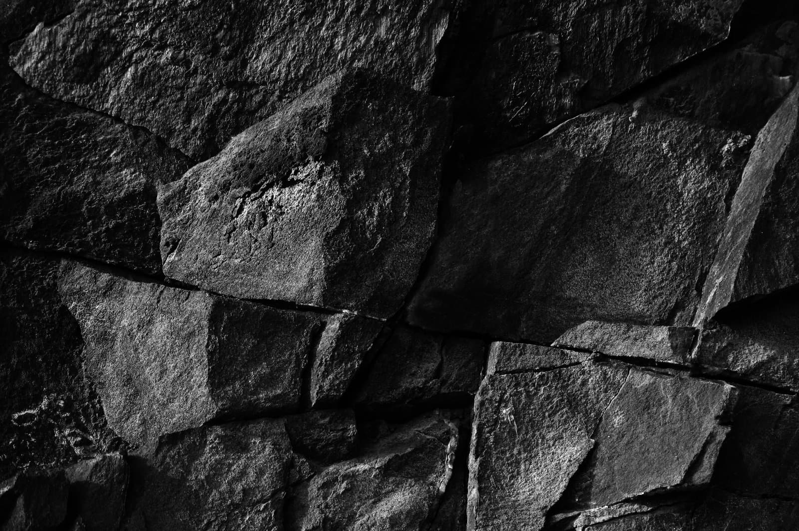 Close-up of a stone wall made of large, irregularly shaped rock blocks