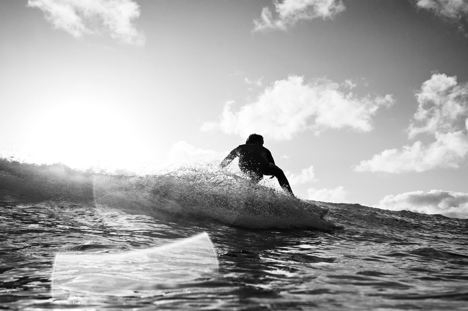A surfer catching a wave in the sun