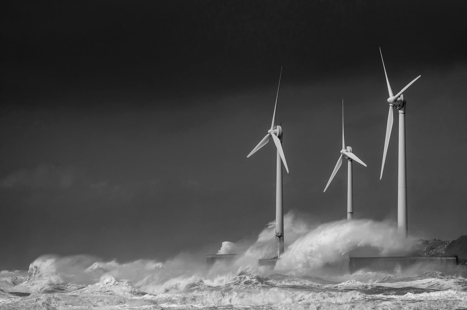 Storm waves smashing over wind turbines