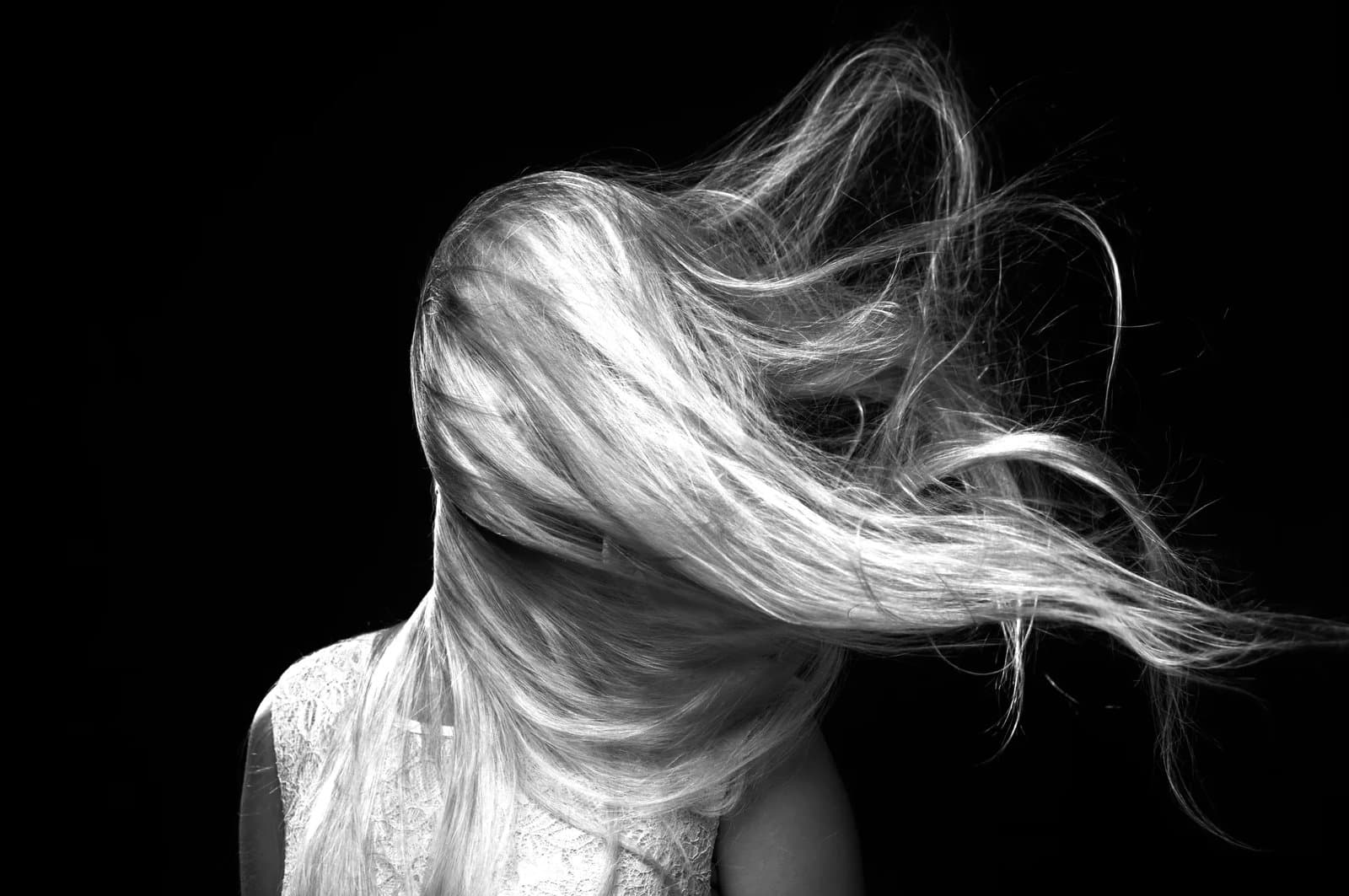 close‑up of long hair blowing across a person’s face